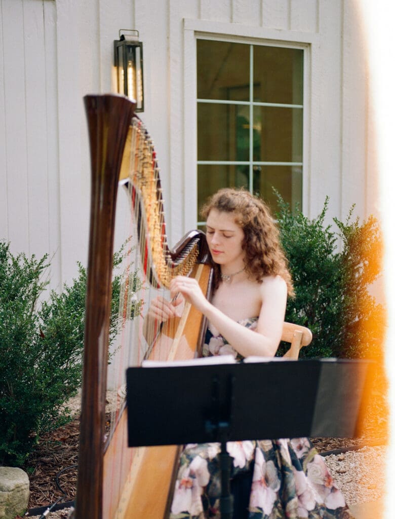 Wedding ceremony musician playing the harp at Carolina Grove