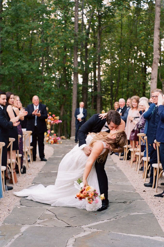 Groom dips bride for a kiss at Carolina Grove wedding ceremony